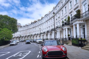 Londra 'da zarif hilal şekilli caddeler, Portico girişleri ve park edilmiş arabaları olan evler.