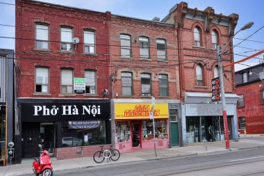 Toronto 'da Queen Caddesi' nde dükkanları ve restoranları olan Viktorya dönemi tuğlalı binalar.