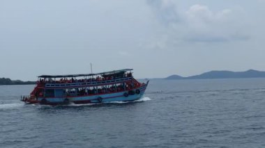 Okyanusta bir tekne, arkasında adalar, güneşli hava, tek bulut, turistler, Tayland. Yüksek kalite 4k görüntü