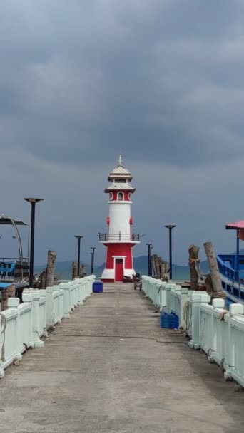 一个记录在码头的红白相间的灯塔 静止不动的拍摄 蓝色的海洋美景 暴风雨般的天气真景 高质量的4K镜头 — 图库视频影像