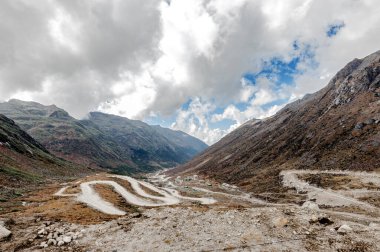 Dağ manzarası, kayaların güzel manzarası, beyaz bulutlarla dolu mavi gökyüzünün tepesindeki pitoresk dağ geçidi..