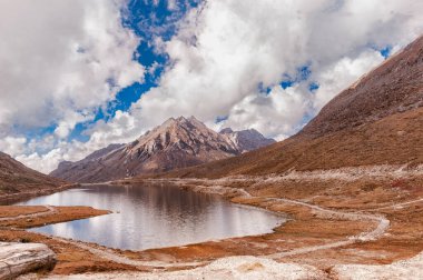 Dağ manzarası, kayaların güzel manzarası, beyaz bulutlarla dolu mavi gökyüzünün tepesindeki pitoresk dağ geçidi..