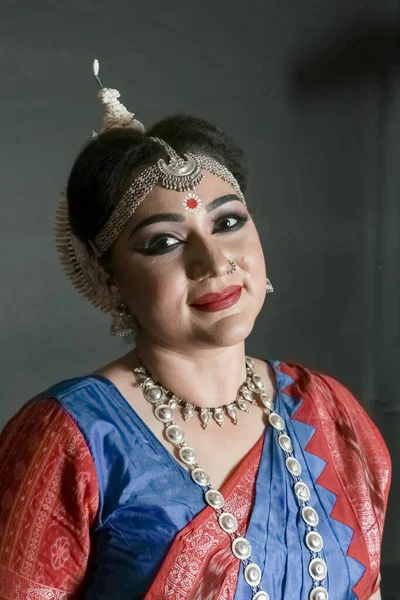 Woman performing Odissi dance in colorful costume. Indian classical dance forms.