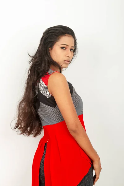工作室拍摄的是一位年轻美丽的印度女模特 穿着便服 头戴红色和灰色设计背心 背景为白色的黑色牛仔裤 时尚风貌 — 图库照片
