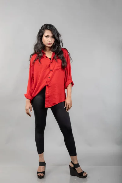 インドの若い女性モデルは 灰色の背景にカジュアルな摩耗 ストック写真 赤シャツとブラックジーンズを着用したロングブラックハイレッドモデル — ストック写真