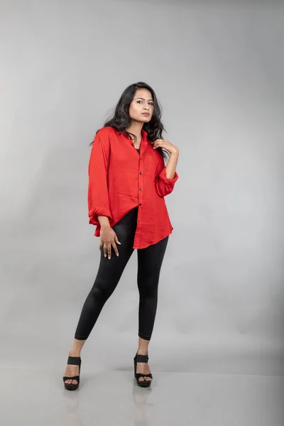 インドの若い女性モデルは 灰色の背景にカジュアルな摩耗 ストック写真 赤シャツとブラックジーンズを着用したロングブラックハイレッドモデル — ストック写真