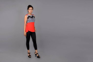 Genç, güzel bir Hintli kadın modelin gündelik kıyafetleriyle stüdyo fotoğrafı. Kırmızı ve gri tasarımcı bluzu ve beyaz arka planda siyah kot pantolon giyiyor. Kadın manken. Moda Portresi.