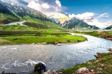 Sersemletici bir dağ, nehir, vadi, kar, mavi gökyüzü, beyaz bulutlar. Himalaya Dağları 'ndaki ulusal otoyolda sakin bir yer.