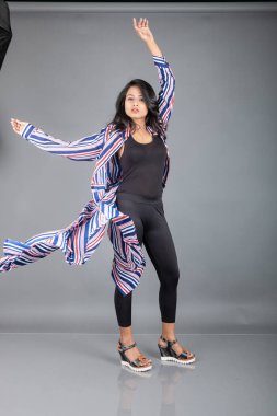 Siyah tayt giyen güzel bir kadın, siyah üst ve kırmızı, mavi, beyaz çizgili tunik. Sıradan giyinen kadın model, reklam çekimi..