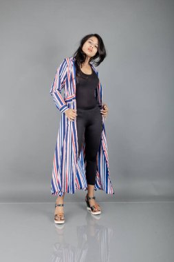 Siyah tayt giyen güzel bir kadın, siyah üst ve kırmızı, mavi, beyaz çizgili tunik. Sıradan giyinen kadın model, reklam çekimi..