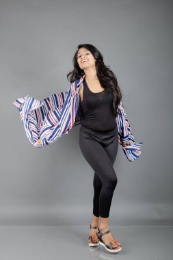 Siyah tayt giyen güzel bir kadın, siyah üst ve kırmızı, mavi, beyaz çizgili tunik. Sıradan giyinen kadın model, reklam çekimi..