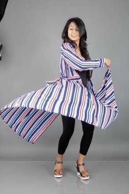 Siyah tayt giyen güzel bir kadın, siyah üst ve kırmızı, mavi, beyaz çizgili tunik. Sıradan giyinen kadın model, reklam çekimi..