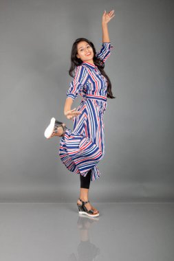 Siyah tayt giyen güzel bir kadın, siyah üst ve kırmızı, mavi, beyaz çizgili tunik. Sıradan giyinen kadın model, reklam çekimi..