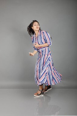 Siyah tayt giyen güzel bir kadın, siyah üst ve kırmızı, mavi, beyaz çizgili tunik. Sıradan giyinen kadın model, reklam çekimi..