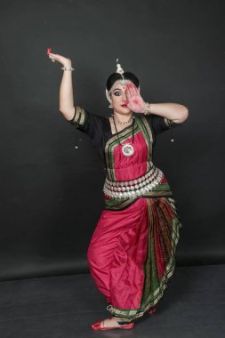 Renkli kostümler içinde Odissi dansı yapan bir kadın. Hint klasik dans formları.