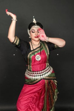Renkli kostümler içinde Odissi dansı yapan bir kadın. Hint klasik dans formları.