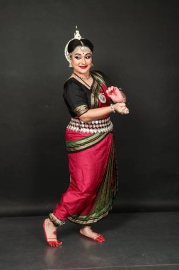 Renkli kostümler içinde Odissi dansı yapan bir kadın. Hint klasik dans formları.