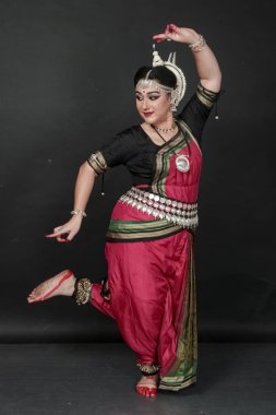 Renkli kostümler içinde Odissi dansı yapan bir kadın. Hint klasik dans formları.