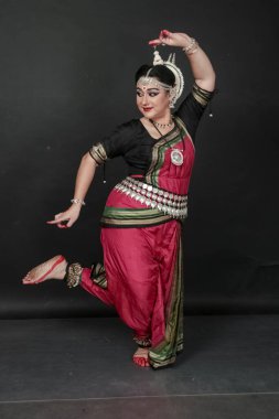 Renkli kostümler içinde Odissi dansı yapan bir kadın. Hint klasik dans formları.