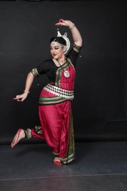 Renkli kostümler içinde Odissi dansı yapan bir kadın. Hint klasik dans formları.