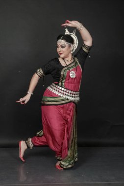 Renkli kostümler içinde Odissi dansı yapan bir kadın. Hint klasik dans formları.