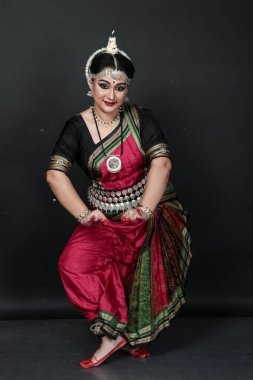 Renkli kostümler içinde Odissi dansı yapan bir kadın. Hint klasik dans formları.