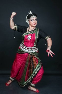 Renkli kostümler içinde Odissi dansı yapan bir kadın. Hint klasik dans formları.