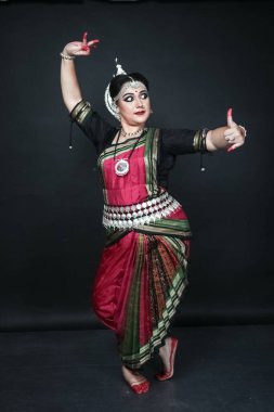 Renkli kostümler içinde Odissi dansı yapan bir kadın. Hint klasik dans formları.