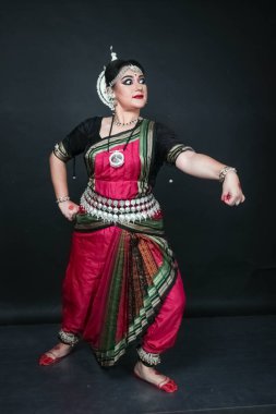Renkli kostümler içinde Odissi dansı yapan bir kadın. Hint klasik dans formları.