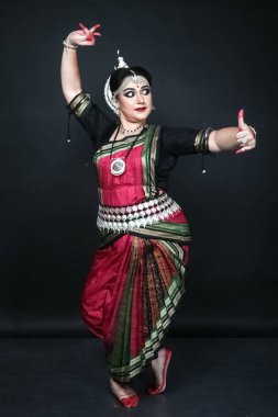 Renkli kostümler içinde Odissi dansı yapan bir kadın. Hint klasik dans formları.