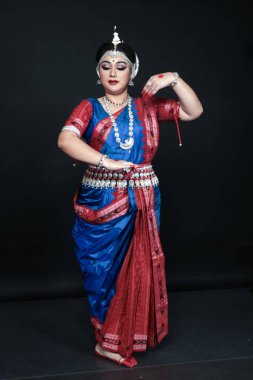 Renkli kostümler içinde Odissi dansı yapan bir kadın. Hint klasik dans formları.