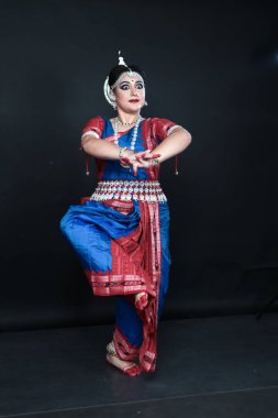 Renkli kostümler içinde Odissi dansı yapan bir kadın. Hint klasik dans formları.