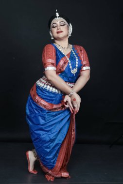 Renkli kostümler içinde Odissi dansı yapan bir kadın. Hint klasik dans formları.