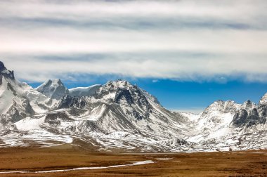 Hindistan 'ın Kuzey Sikkim kentindeki Gurudongmar Gölü' nde kar bulutlarıyla dolu mavi gökyüzüne karşı sersemletici kar manzarası. Dağ manzarası