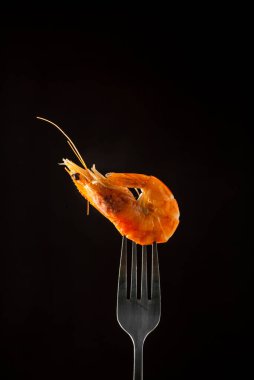 Çatalda buharda karides buharı izole edilmiş siyah arkaplan kopyalama alanı. İzole edilmiş siyah arka plan ışığı arka plan yiyecek konsepti yemeye hazır