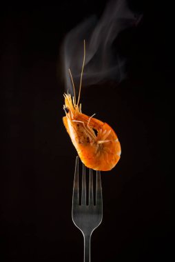 Çatalda buharda karides buharı izole edilmiş siyah arkaplan kopyalama alanı. İzole edilmiş siyah arka plan ışığı arka plan yiyecek konsepti yemeye hazır