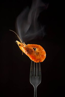 Çatalda buharda karides buharı izole edilmiş siyah arkaplan kopyalama alanı. İzole edilmiş siyah arka plan ışığı arka plan yiyecek konsepti yemeye hazır