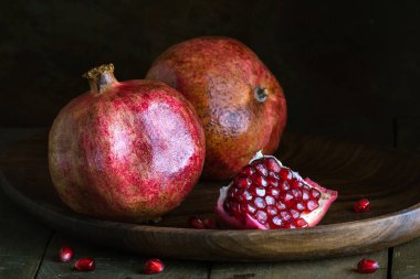 Nar tohumları taze olgun ahşap arka plan karanlık bağlar hala canlı kırmızı vitaminler ahşap tabaklar tatlı