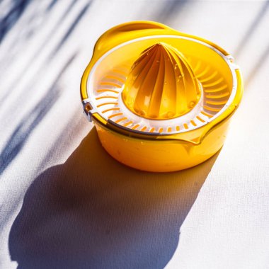 Meyveli limonlu portakal sıkacağı elle sıkma, meyve sıkma aleti. Sarı Turuncu, plastik, beyaz masa ışığı.