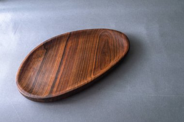 El yapımı ceviz yuvarlak ahşap palet, ahşap doğrama tahtası boş armut gri arka plan kasesi ahşap halkalar el yapımı ahşap sehpa sehpası koyu kahverengi tepsi servis ediliyor.