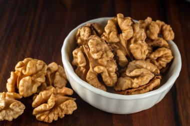 bowl of Shelled walnut wooden table healthy food Close-up  kernels and whole walnuts on rustic old