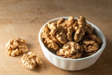bowl of Shelled walnut wooden table healthy food Close-up  kernels and whole walnuts on rustic old