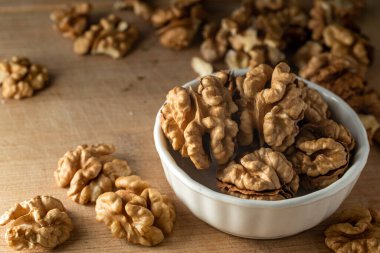 bowl of Shelled walnut wooden table healthy food Close-up  kernels and whole walnuts on rustic old