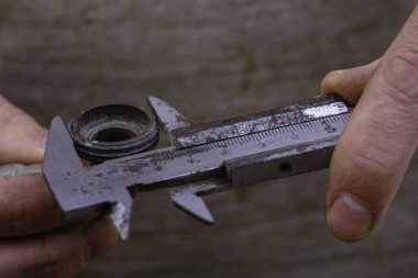 Metal shtangel çubuğu otomatikman mekanik olarak istenen kısmı dikkatlice ölçer. İşçi, flanjın iç çapını ölçüyor.