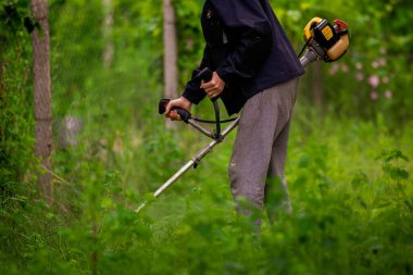Kafkas bahçıvanı Elle çim biçme makinesi ya da elektrikli ot biçme makinesi ya da çim biçme makinesi Mowe benzini.