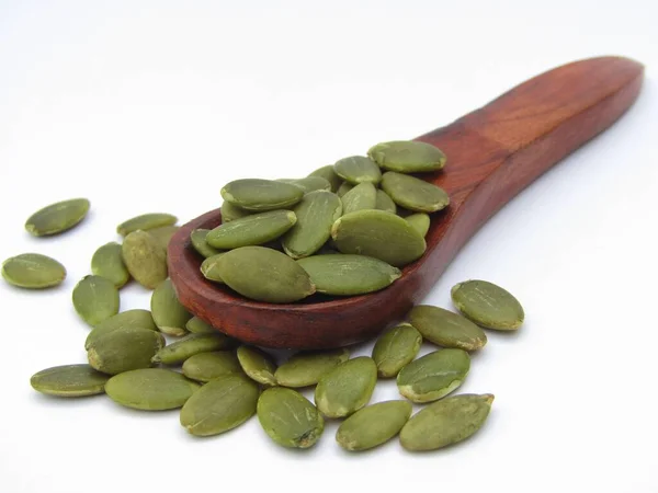 stock image Pumpkin Seeds on a wooden spoon on white background 