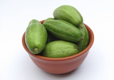 Beyaz arka planda bir kasede taze sivri su kabağı. 