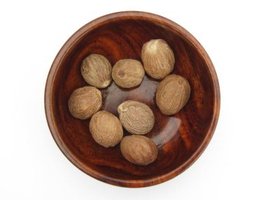 Beyaz arka planda tahta bir kasede Nutmeg. 