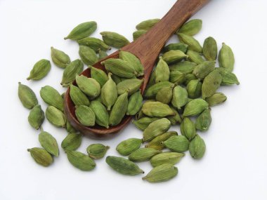 Elettaria kakule ya da beyaz arka planda tahta kaşıkta yeşil kakule. 