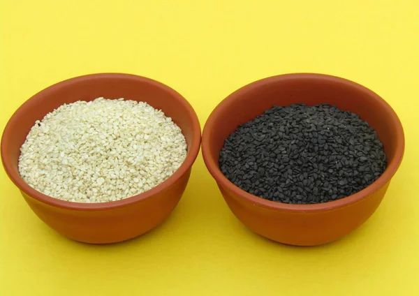 Schwarzer Sesam Und Weiße Sesamsamen Schalen Auf Gelbem Hintergrund — Stockfoto